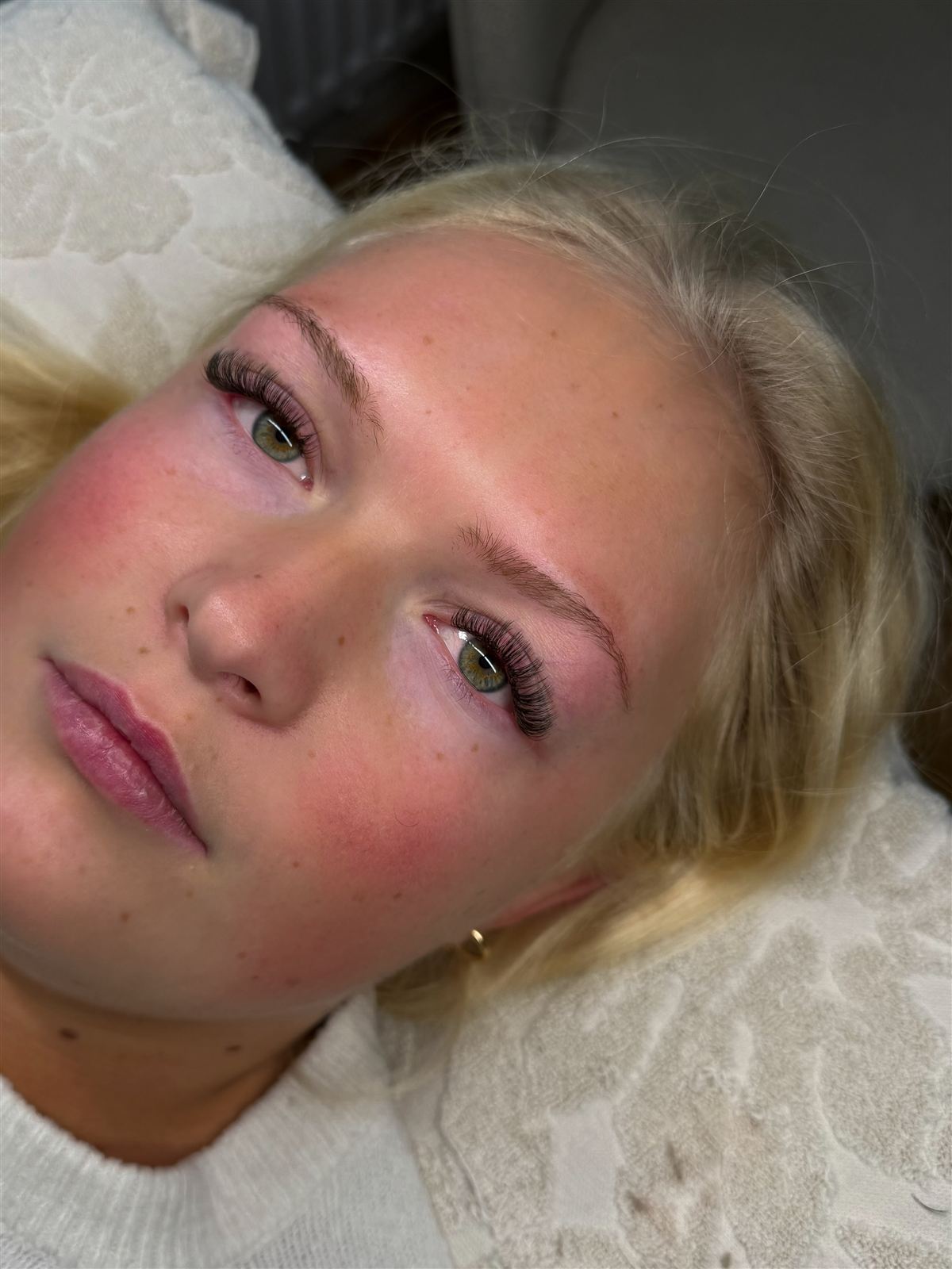 Kund med volymfransar och formade bryn efter behandling hos MLA beautystudio